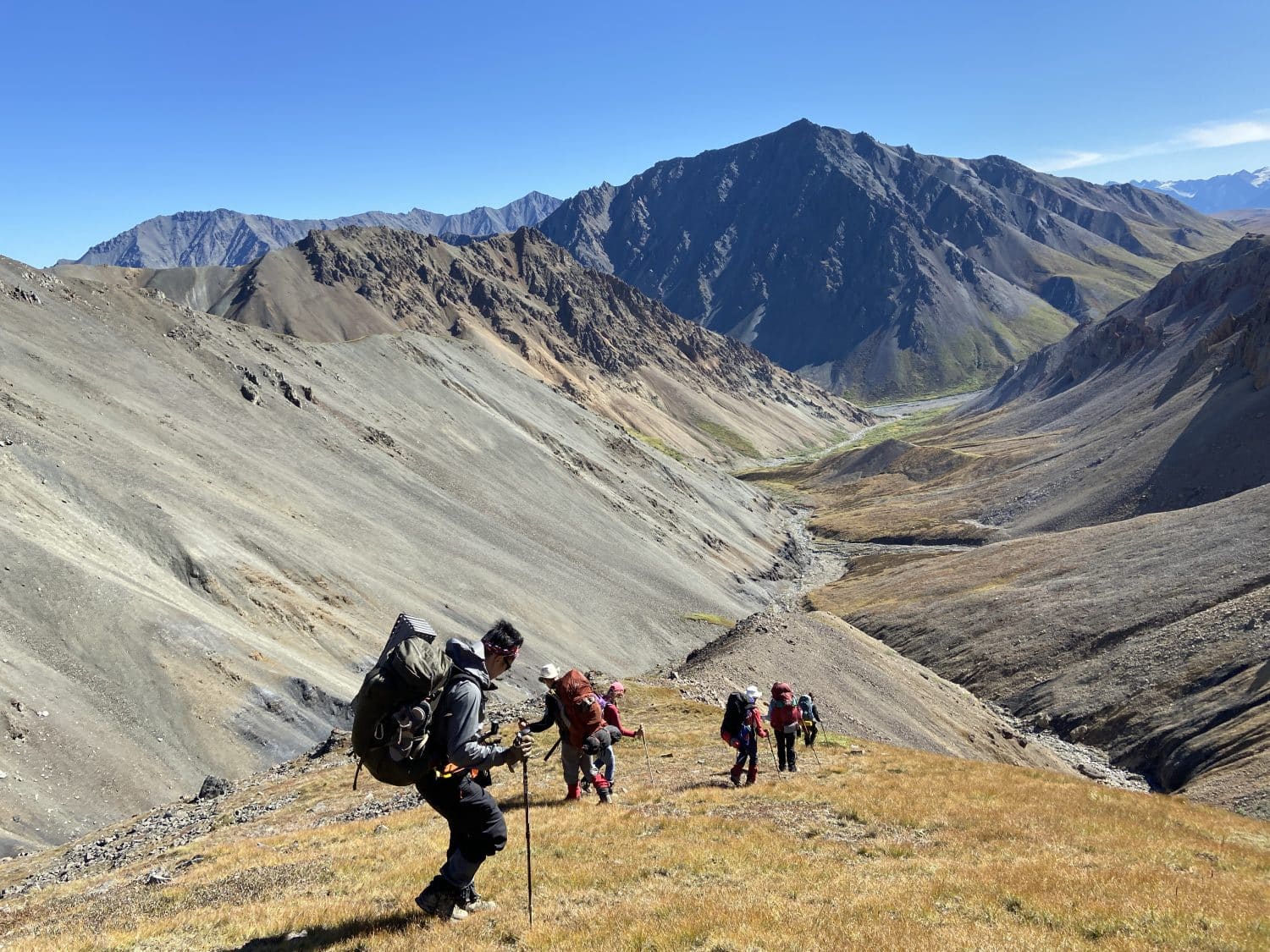 Backpackers going down a ridge into a valley in Kluane National Park